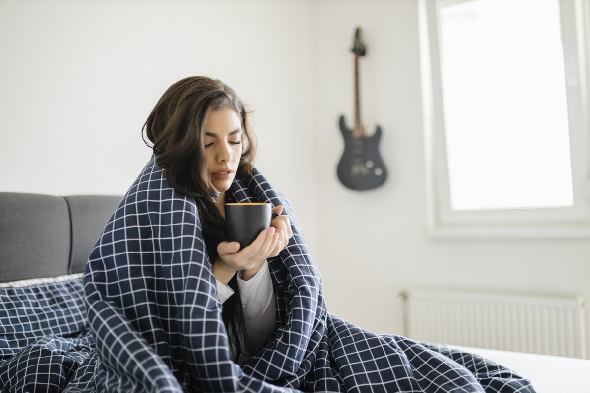 A sick woman lying in bed suffering from high fever. Cold flu and migraine